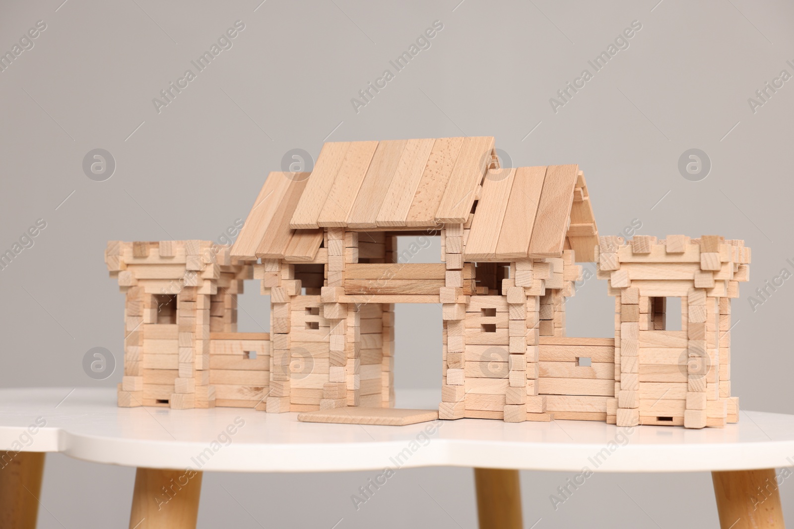 Photo of Wooden entry gate and box on white table against light grey background. Children's toy