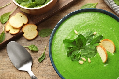 Photo of Flat lay composition with fresh green healthy spinach soup on wooden table