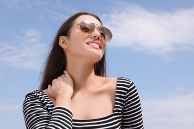 Beautiful smiling woman wearing stylish sunglasses outdoors