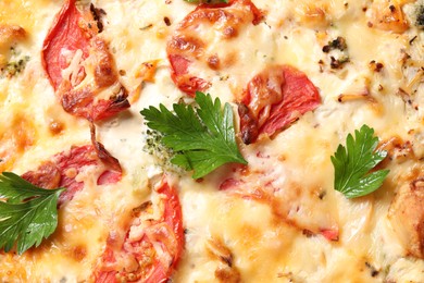 Photo of Tasty quiche with tomatoes, parsley and cheese as background, closeup