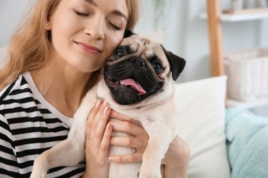 Woman with cute pug dog at home. Animal adoption