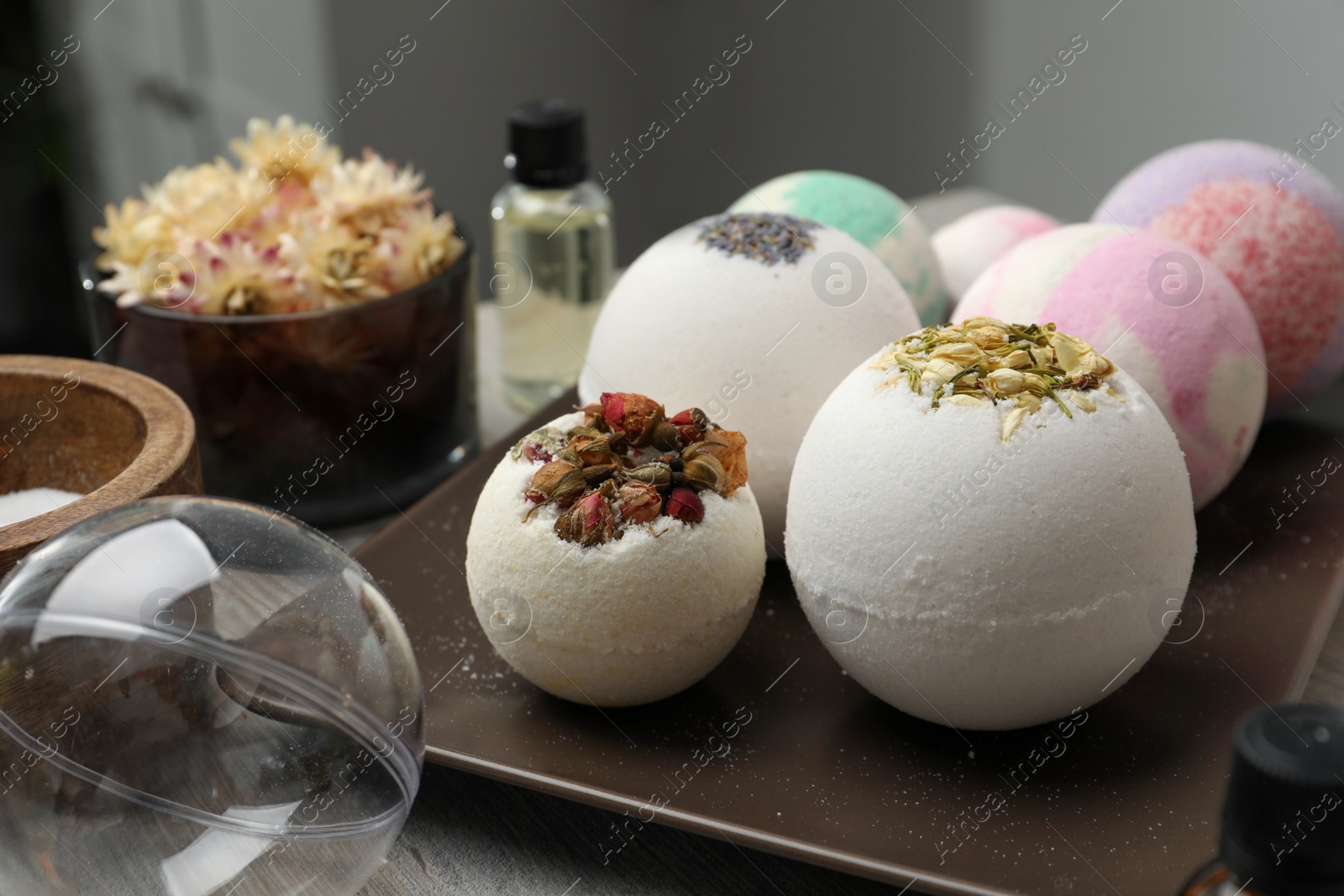 Photo of Plate with different bath bombs on wooden table, closeup