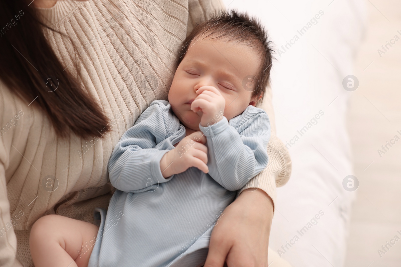 Photo of Mother with her sleeping newborn baby on bed, closeup