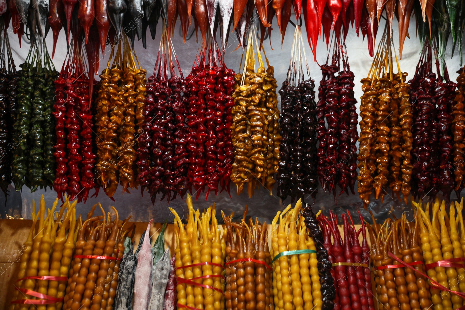 Photo of Bunches of different delicious churchkhelas at market