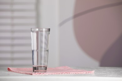 Glass of pure water on table indoors, space for text