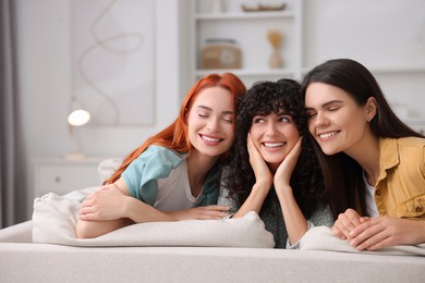 Photo of Portrait of happy young friends on sofa at home