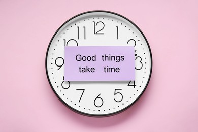 Photo of Card with phrase Good Things Take Time and clock on pink background, top view. Motivational quote