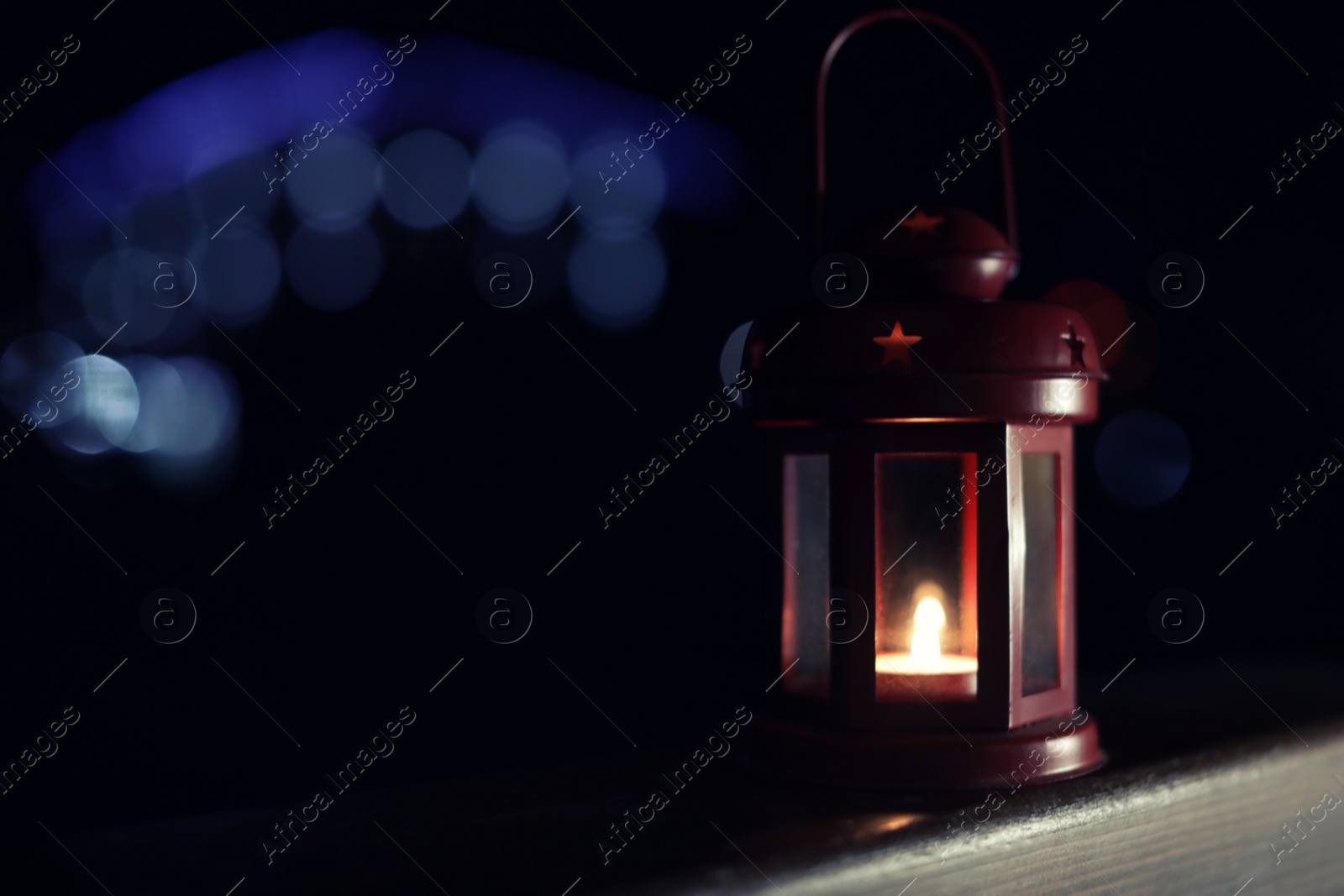 Photo of Lantern on wooden railing outdoors against blurred background, space for text. Winter night