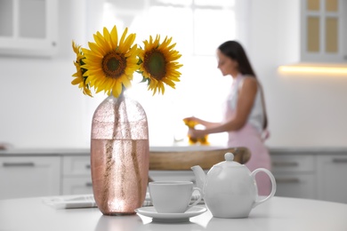 Bouquet of beautiful sunflowers on table in kitchen