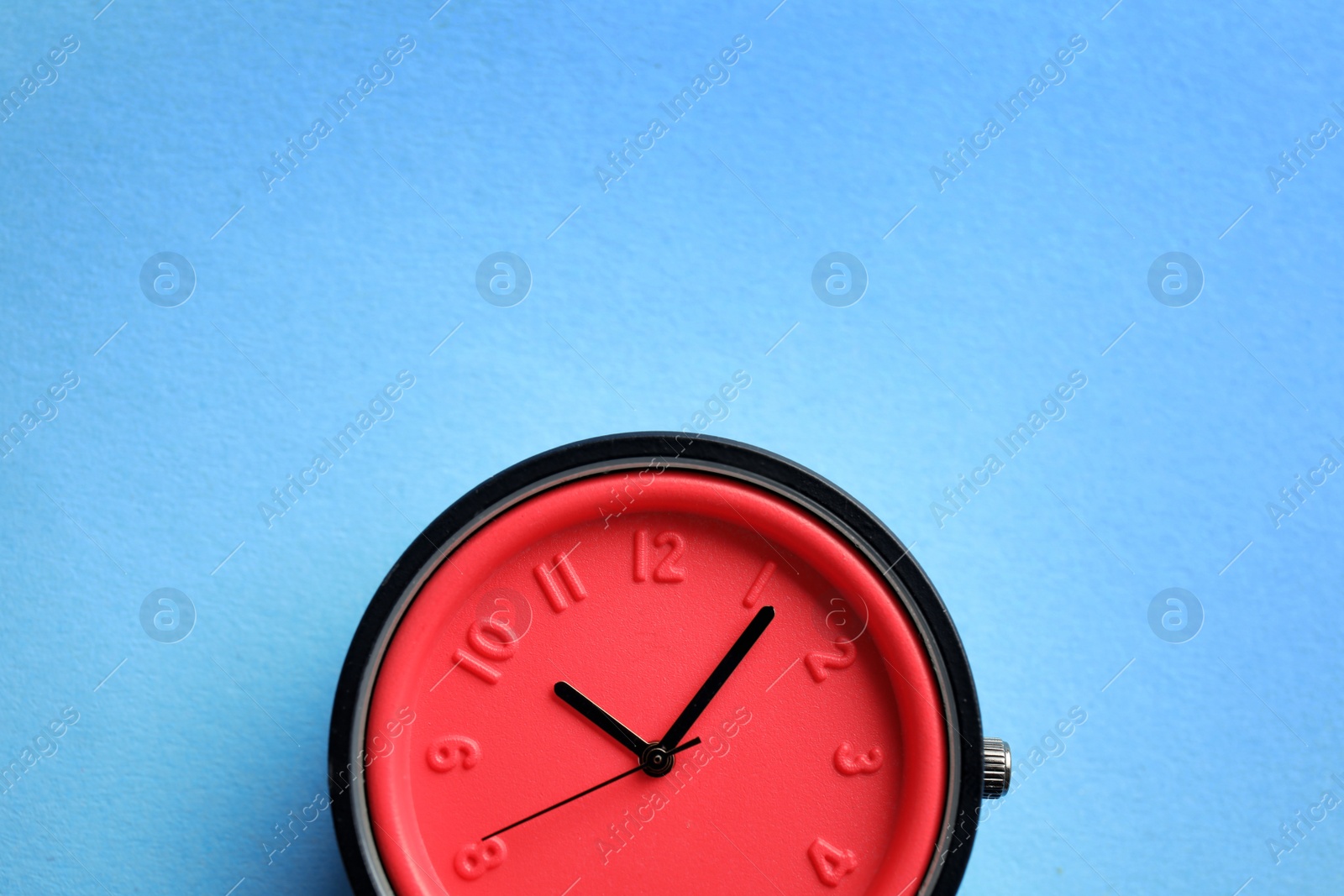 Photo of Stylish bright wrist watch on color background, top view with space for text. Fashion accessory