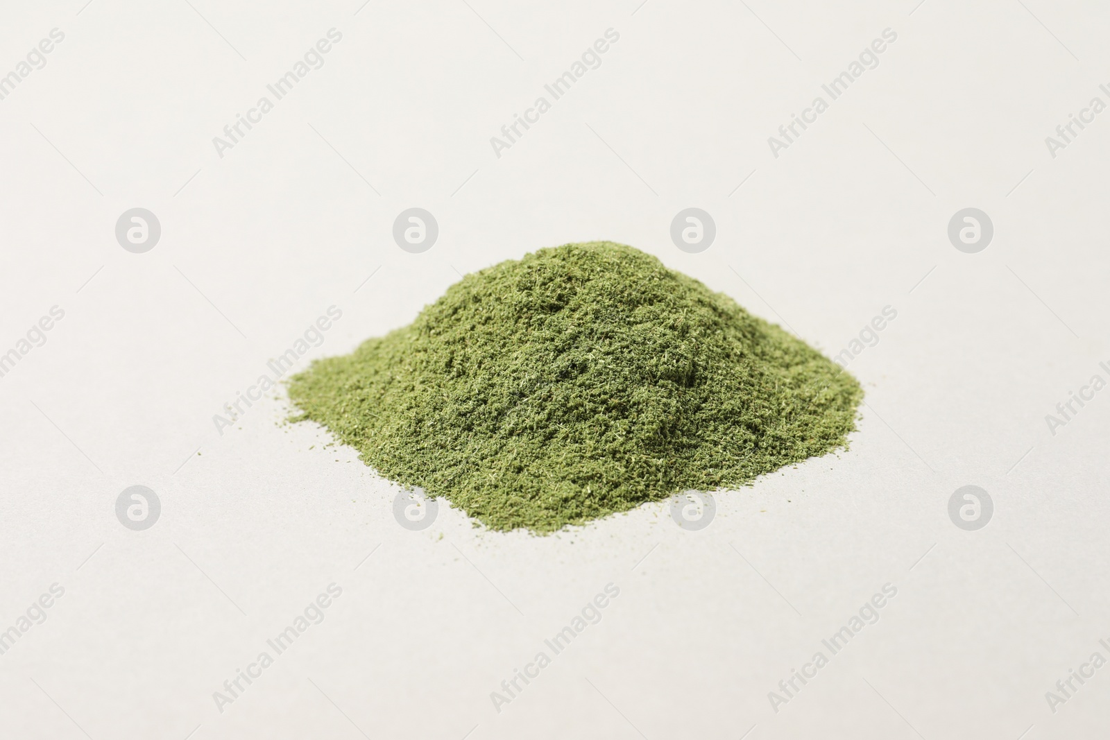 Photo of Pile of wheat grass powder on light table, closeup