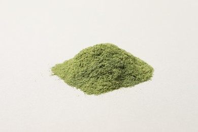 Pile of wheat grass powder on light table, closeup