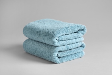 Photo of Stack of fresh fluffy towels on grey background