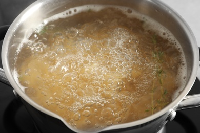 Photo of Cooking pasta in pot on stove, closeup view