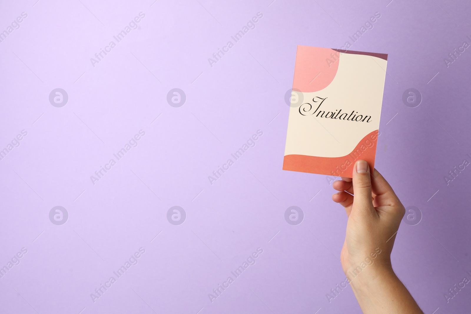 Photo of Woman holding beautiful card with word Invitation on lilac background, closeup. Space for text