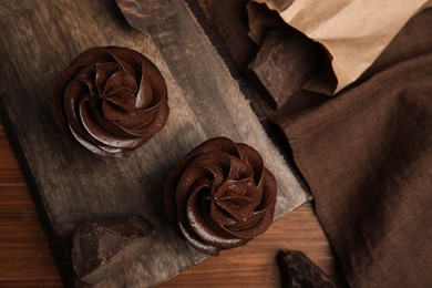 Photo of Flat lay composition with delicious chocolate cupcakes on wooden table