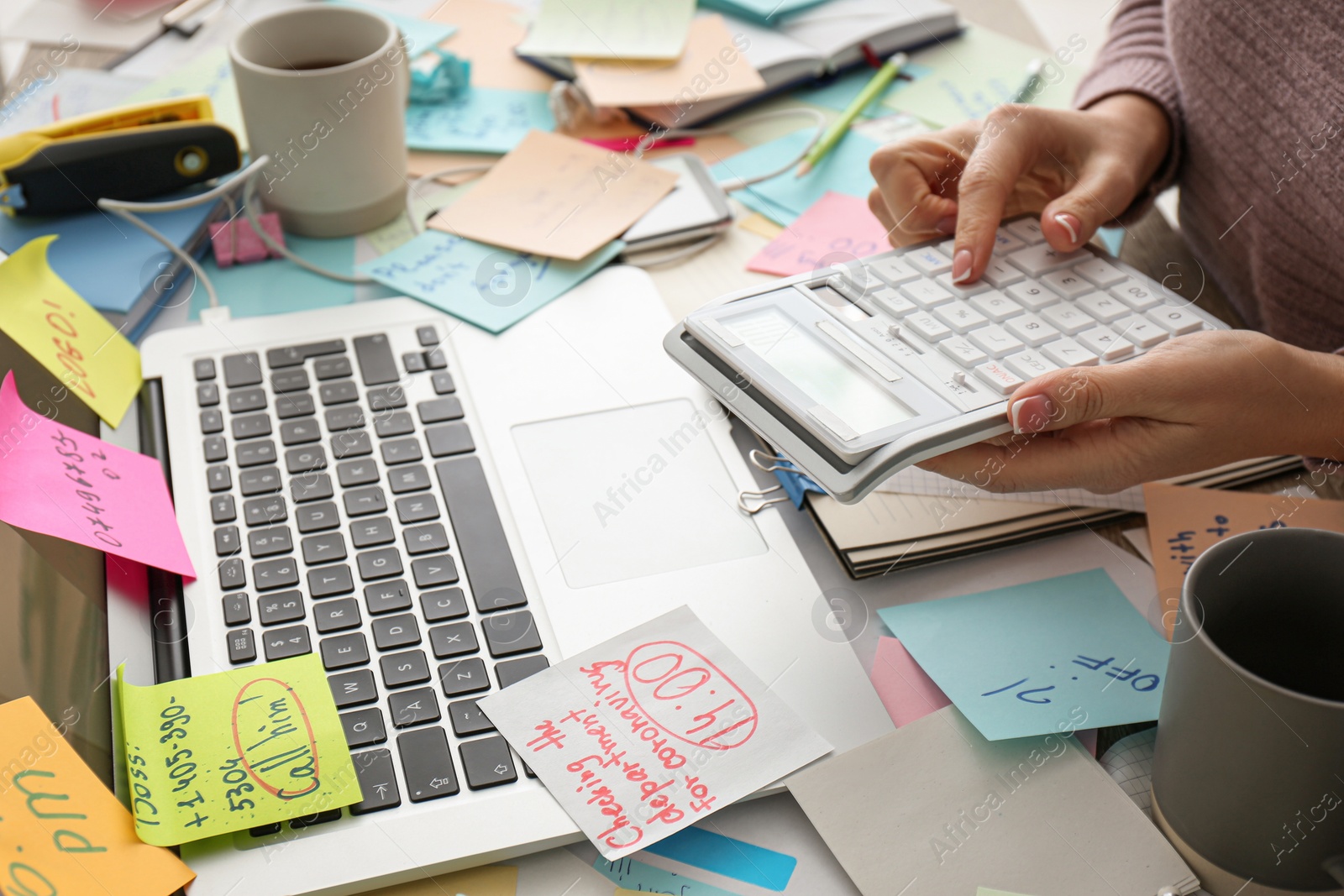 Photo of Overwhelmed woman working at messy office desk, closeup