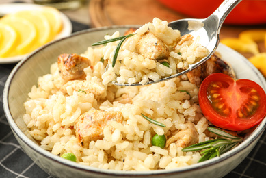 Delicious chicken risotto with tomato on table, closeup