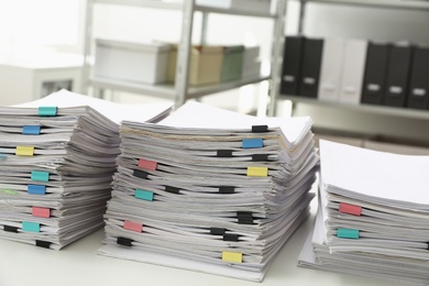 Stacks of documents with paper clips on office desk