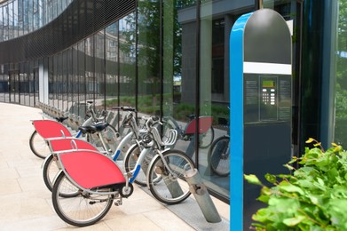 Photo of Payment terminal near parking lot with many bicycles outdoors