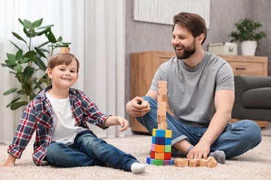 Happy dad and son having fun with building cubes at home