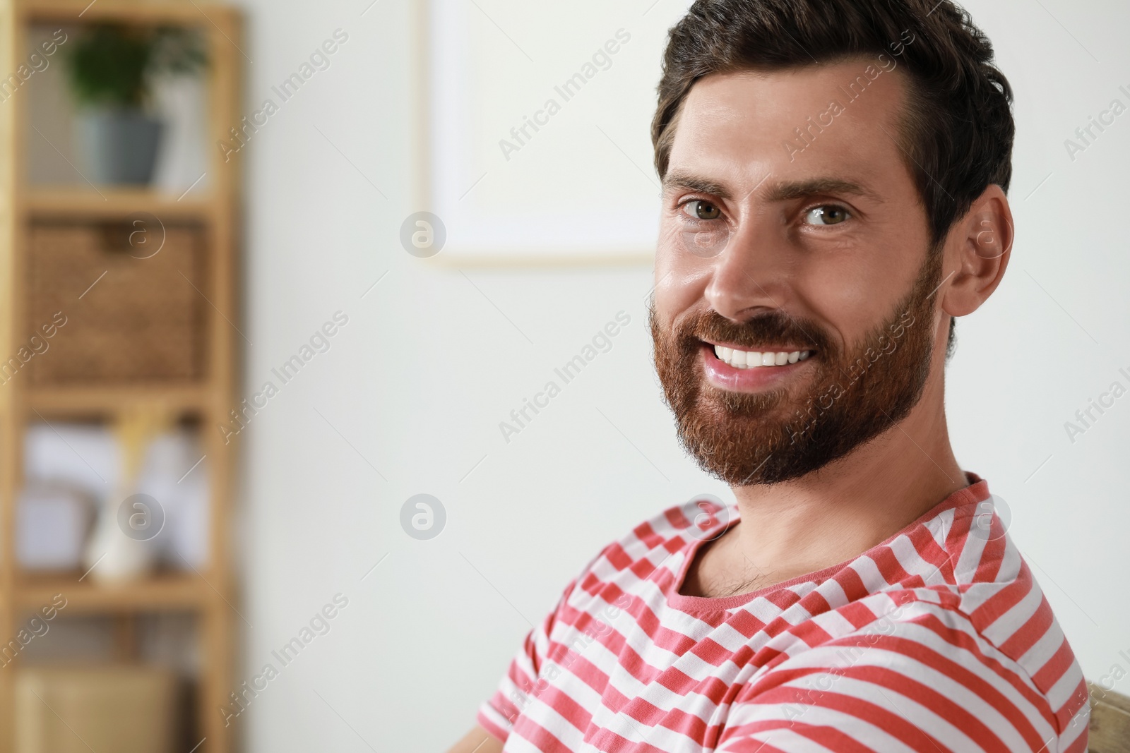 Photo of Portrait of handsome bearded man at home, space for text