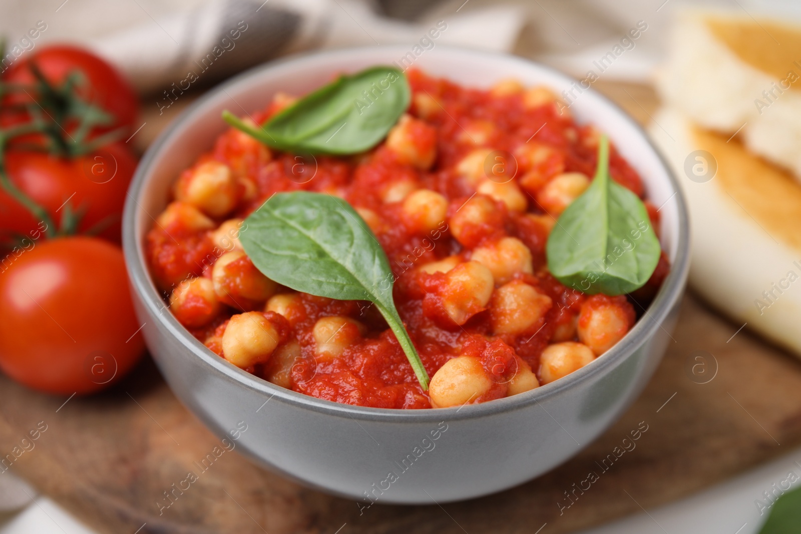 Photo of Delicious chickpea curry served on wooden board, closeup