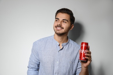 MYKOLAIV, UKRAINE - NOVEMBER 28, 2018: Young man with Coca-Cola can on white background