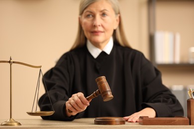 Photo of Judge striking mallet at wooden table indoors, selective focus