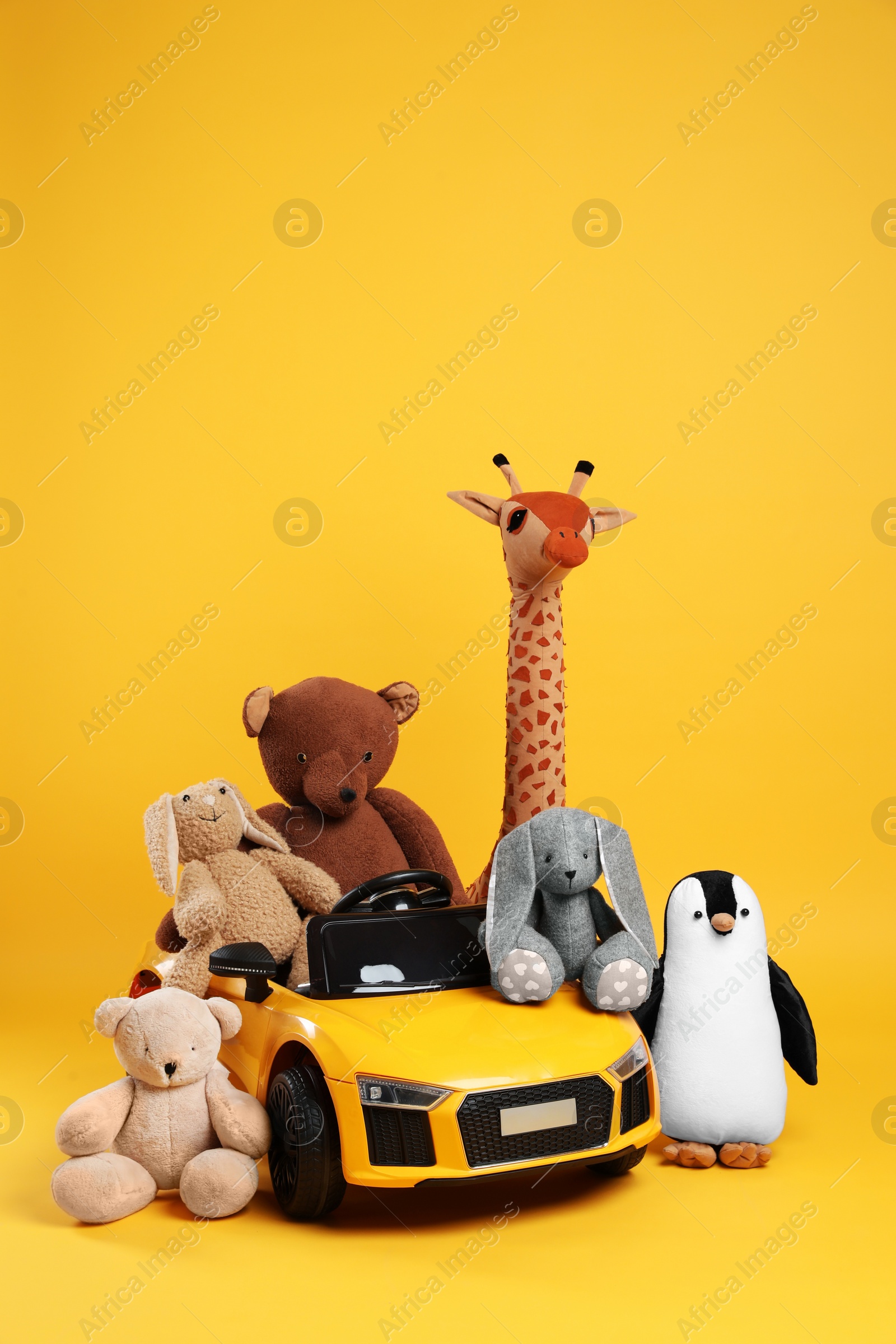 Photo of Child's electric car with other toys on yellow background