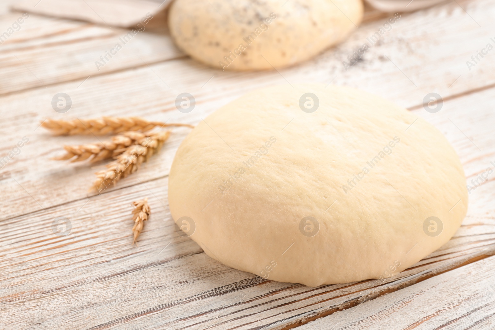 Photo of Fresh raw dough on wooden table