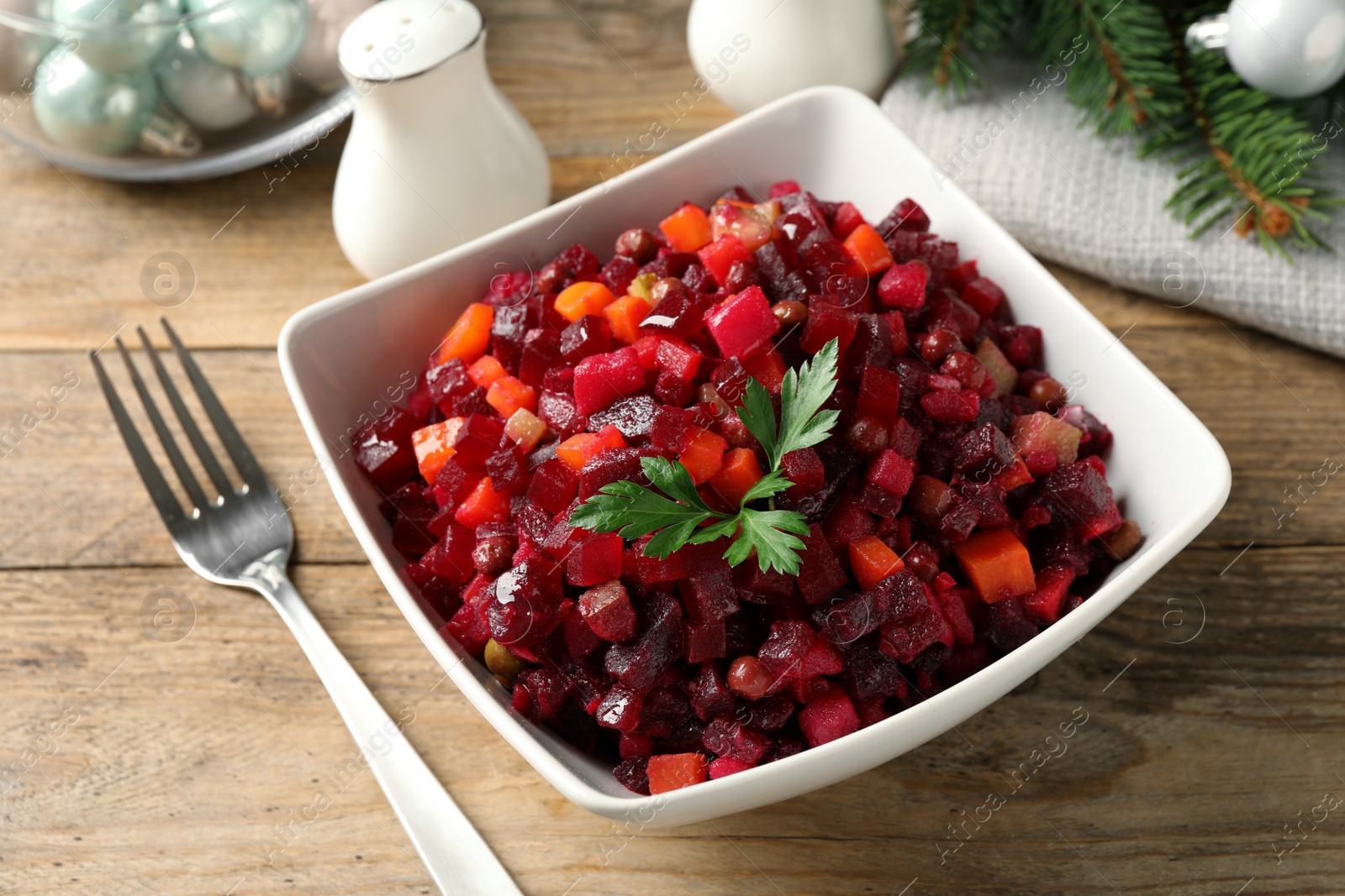 Photo of Traditional Russian salad vinaigrette served on wooden table