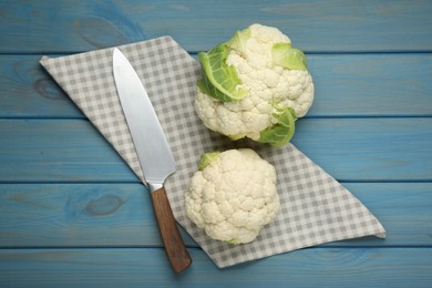Photo of Fresh whole cauliflowers on light blue wooden table, top view
