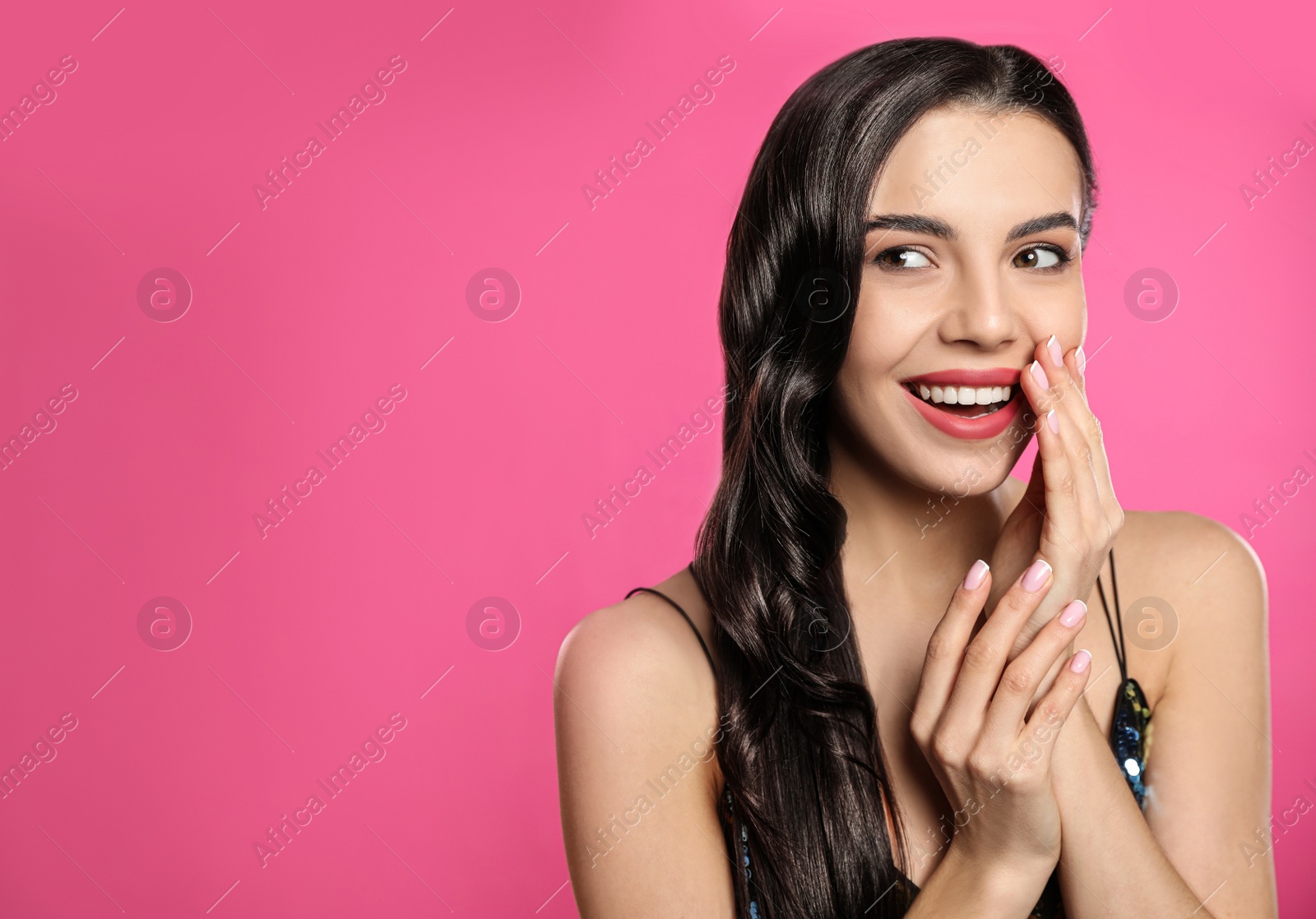 Photo of Portrait of surprised woman on pink background. Space for text