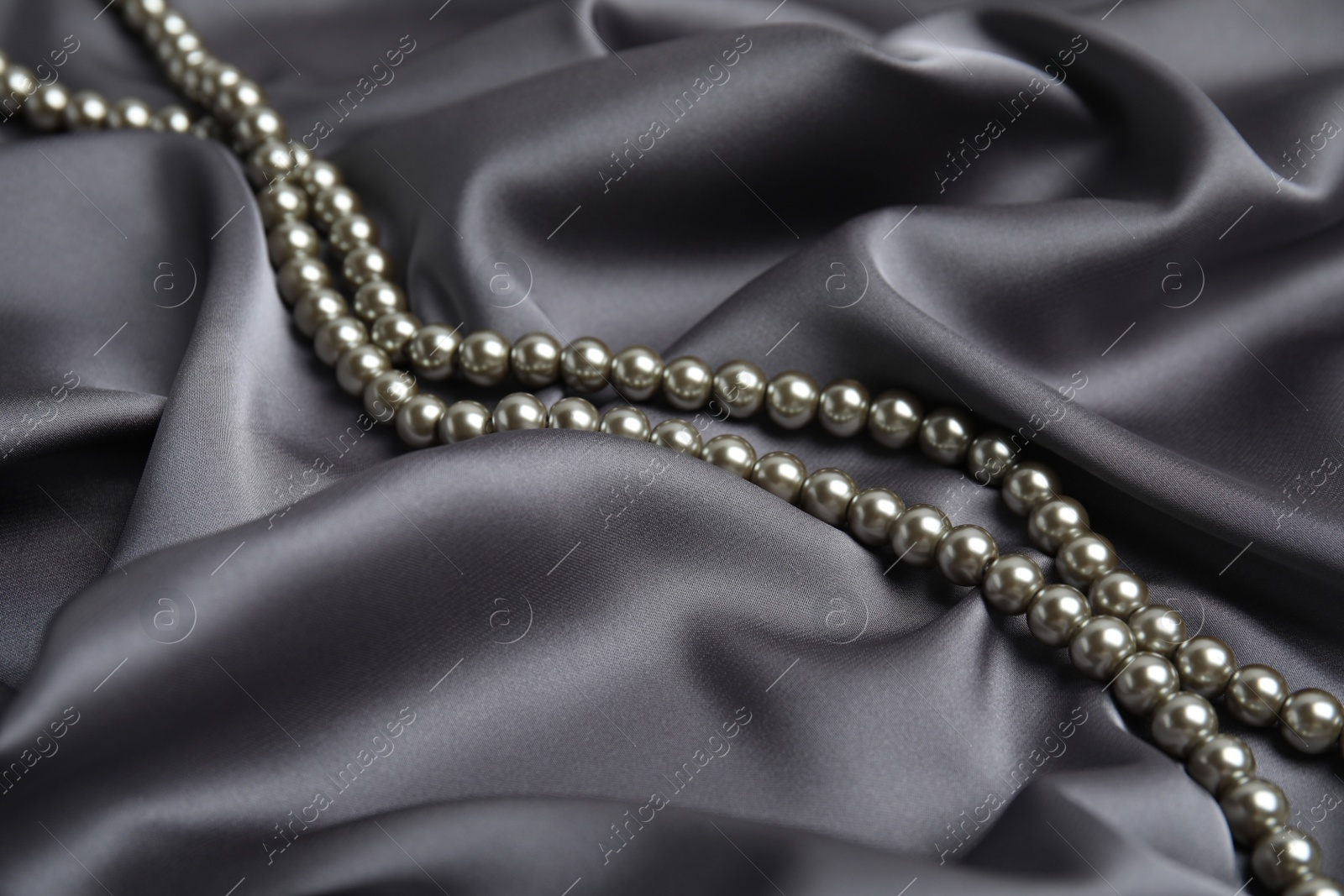 Photo of Beautiful silver pearls on delicate grey silk