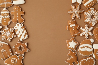 Photo of Different Christmas gingerbread cookies on brown background, flat lay. Space for text