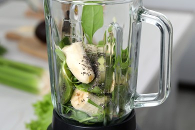 Photo of Blender with ingredients for green smoothie indoors, closeup