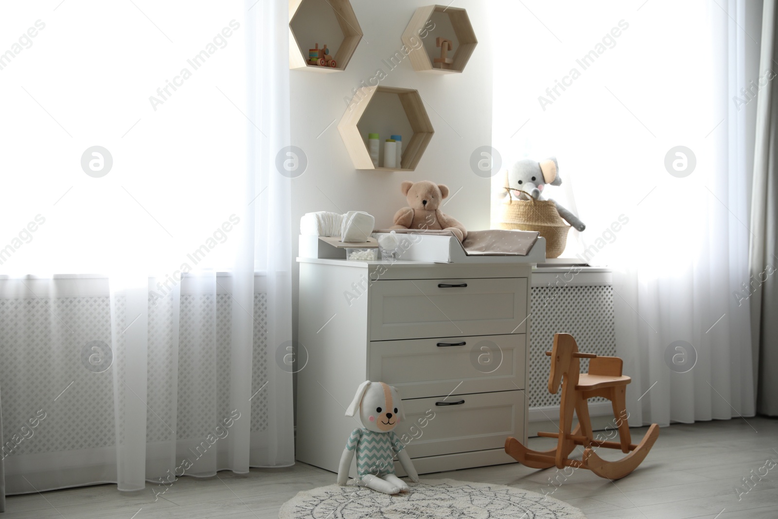 Photo of Beautiful baby room interior with toys and modern changing table