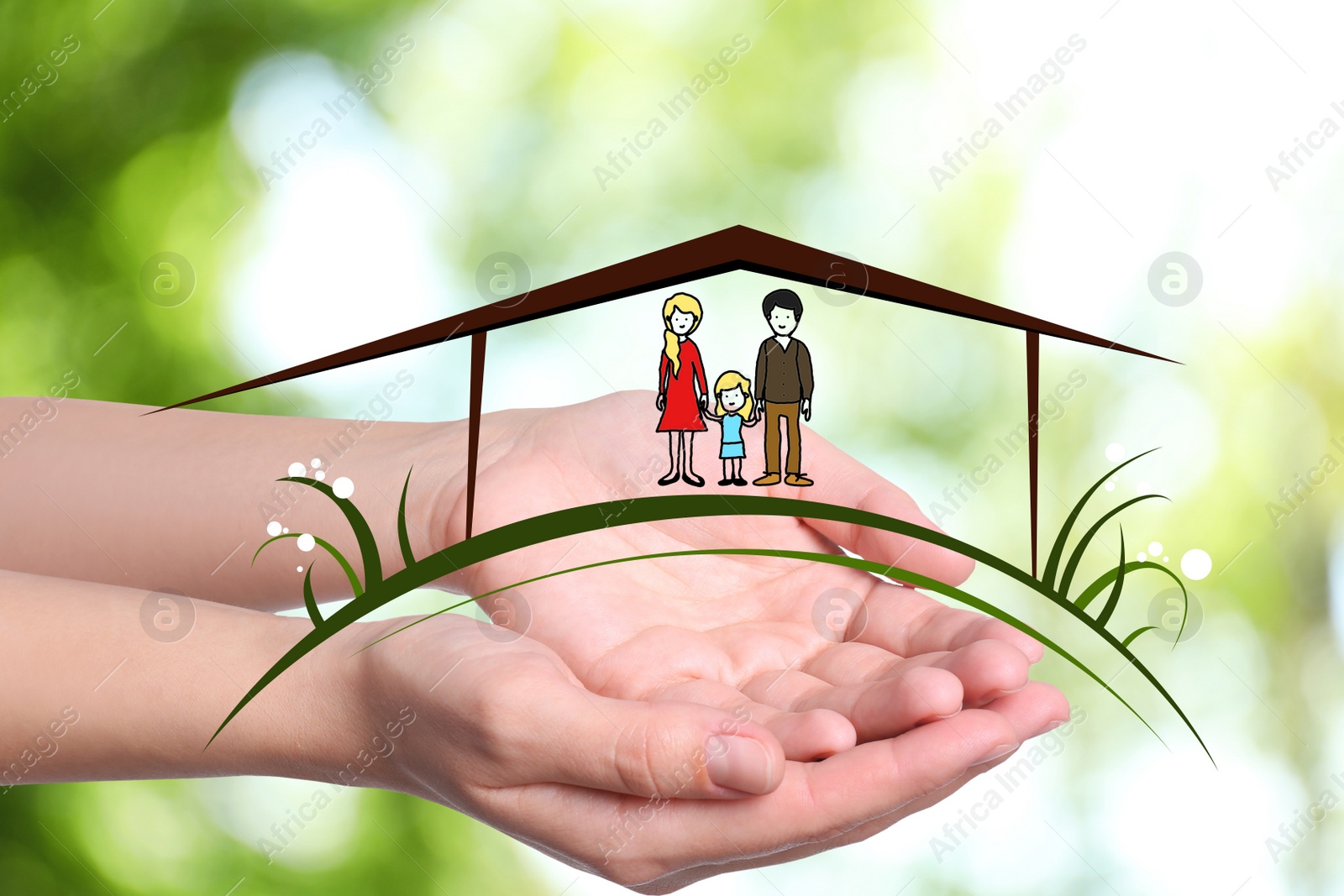 Image of Woman demonstrating illustration of house with family on blurred green background, closeup