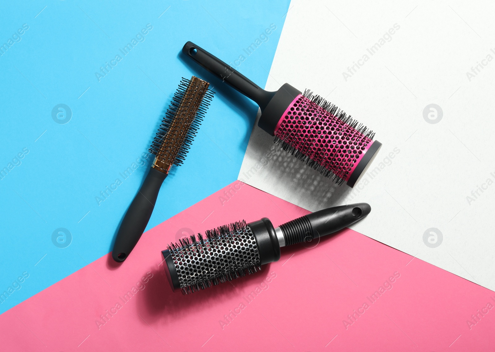 Photo of Round hair brushes on color background, flat lay