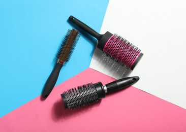 Round hair brushes on color background, flat lay