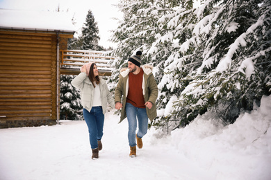 Lovely couple spending time together on snowy day. Winter vacation