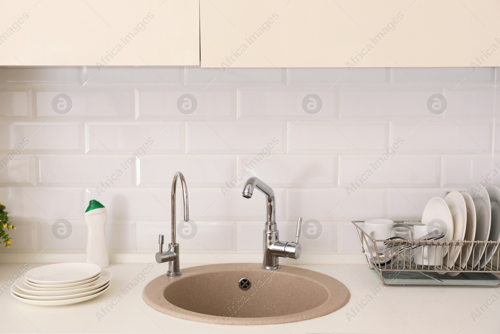 Photo of Clean dishes on counter near kitchen sink indoors