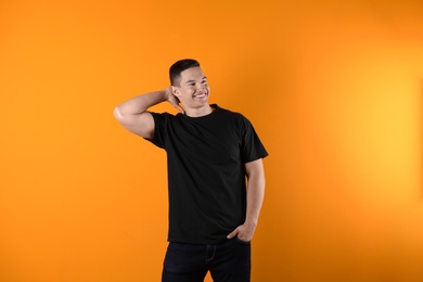 Photo of Young man in black t-shirt on color background. Mockup for design