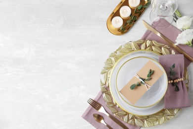 Elegant festive table setting on light background, flat lay. Space for text