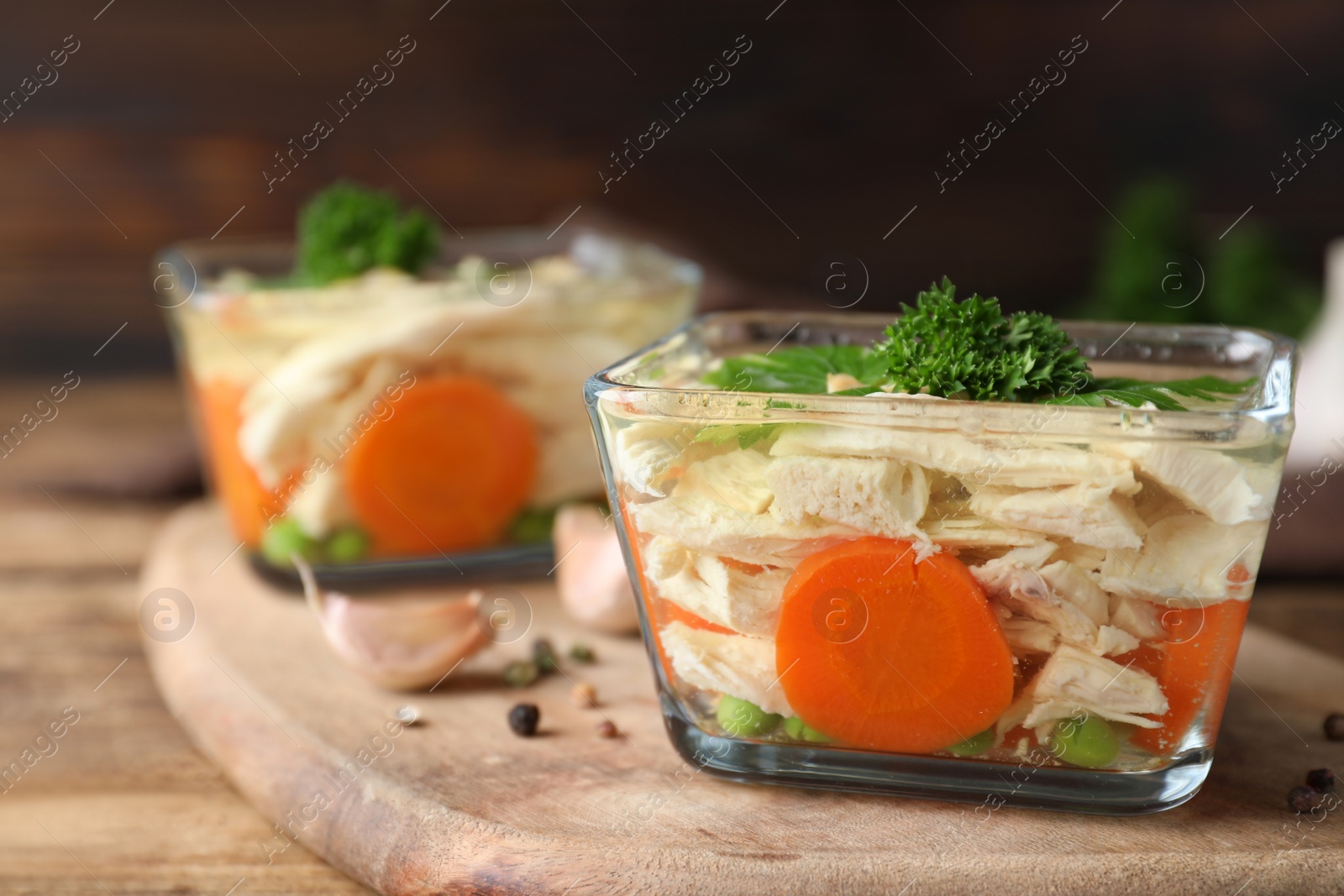 Photo of Delicious chicken aspic served on wooden board, closeup