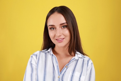 Photo of Beautiful young woman in casual outfit on yellow background