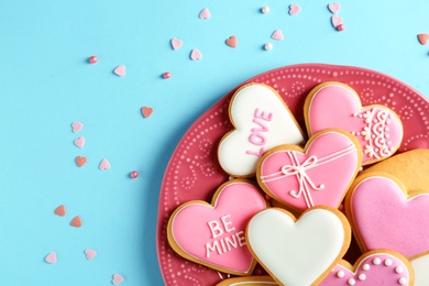 Photo of Composition with decorated heart shaped cookies and space for text on color background, top view