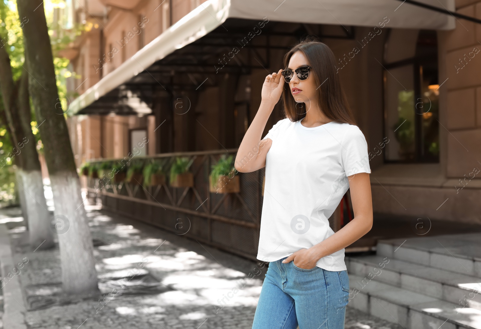 Photo of Young woman wearing white t-shirt on street