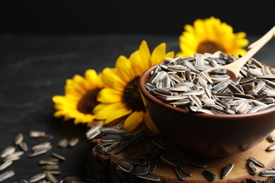 Photo of Raw sunflower seeds and flowers on table, closeup. Space for text
